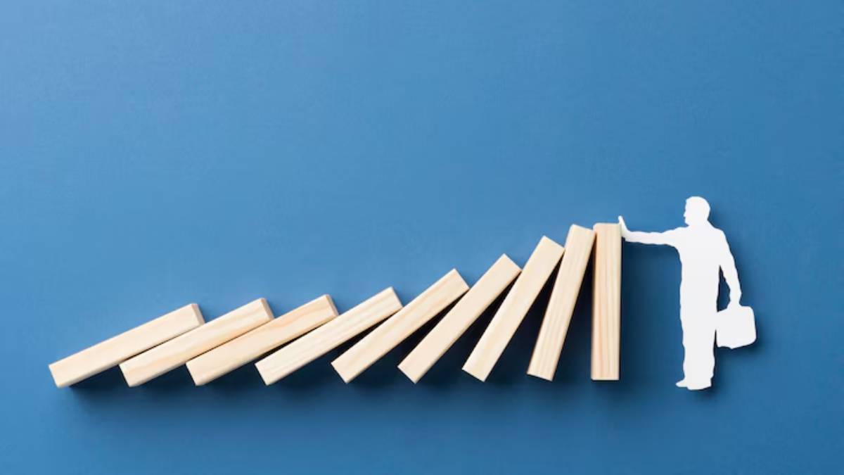 A cut-out figure of a man in a suit reaches toward a series of angled wooden blocks, symbolizing progress or support against a blue background.