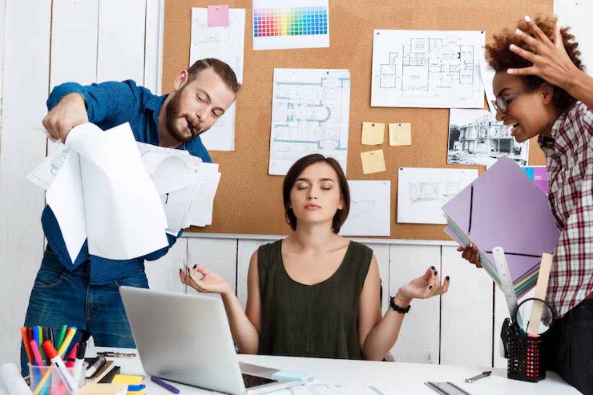 A tense office scene with one person gesturing while two others argue and hold papers, surrounded by design plans on a bulletin board.